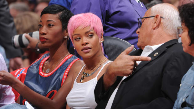 Rihanna at a basketball game with pink hair